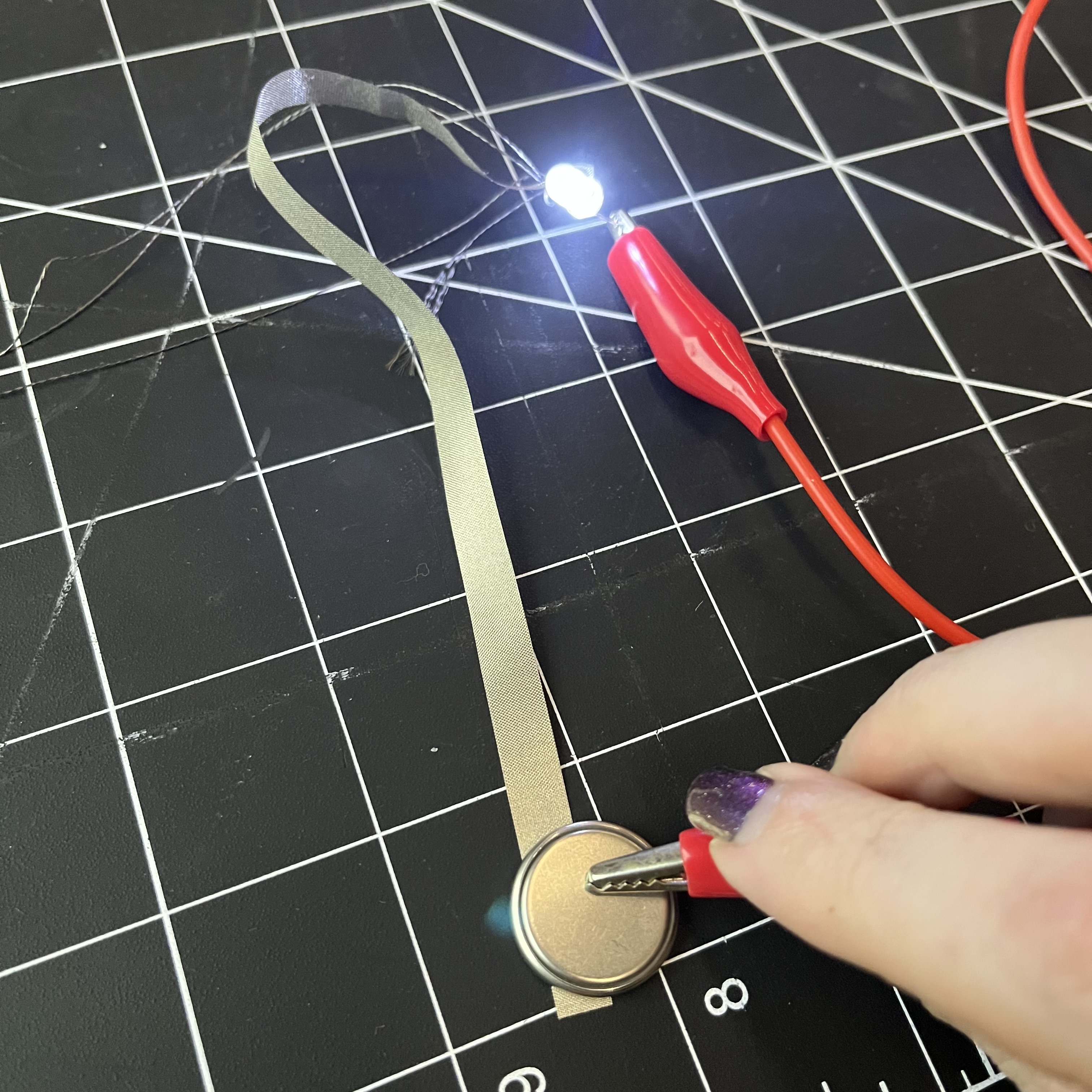 I expanded the ribbon circuit with alligator clips to see if it would work. It did, however you can't clip the battery or it won't work because it's touching both the positive and negative sides at the same time. This only worked when I was pressing the clip against the correct side of the battery.